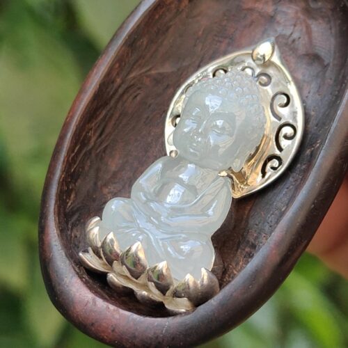 a small white stone statue in a wooden spoon