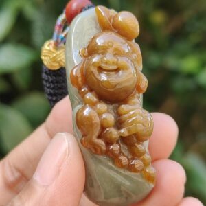 Una mano sosteniendo un colgante de jade.