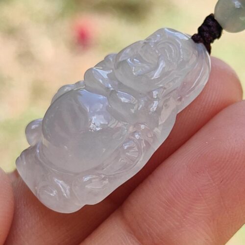 a hand holding a jade pendant