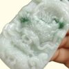 a hand holding a jade carving