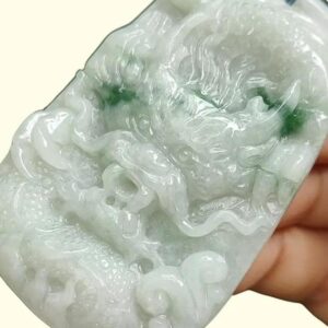 a hand holding a jade carving
