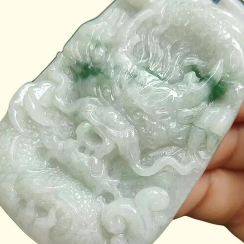 a hand holding a jade carving
