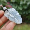 a hand holding a leaf shaped pendant