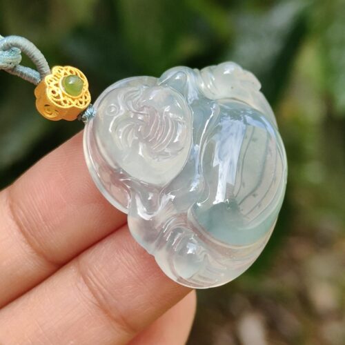 Una mano sosteniendo un colgante de jade.