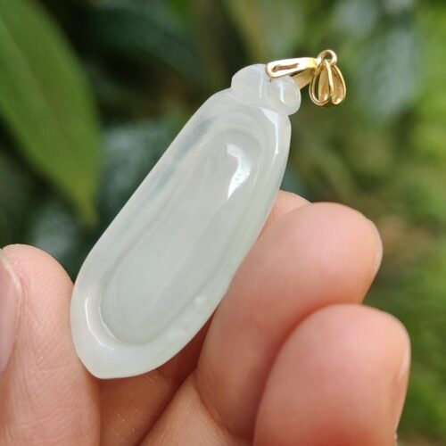 Una mano sosteniendo un colgante de jade.