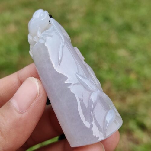 a hand holding a carved white stone
