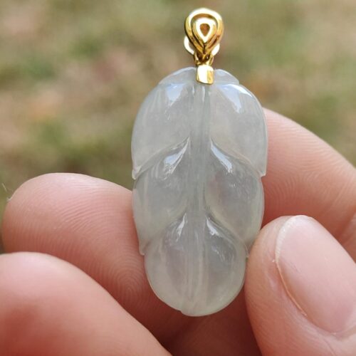 una persona sosteniendo un colgante de jade