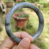 a hand holding a round stone ring