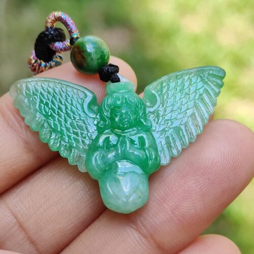 tangan memegang liontin malaikat hijau