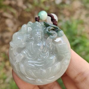 Una mano sosteniendo un colgante de jade.