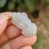 Una mano sosteniendo un colgante de jade.