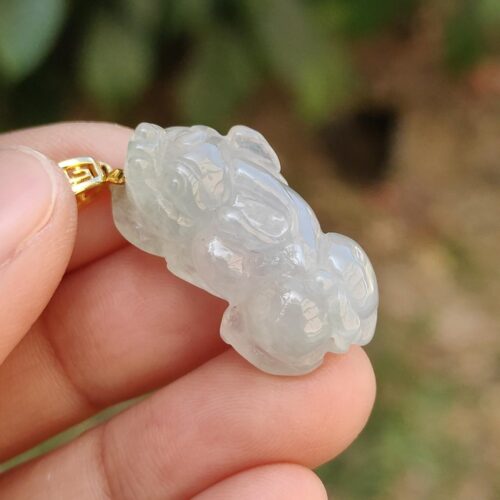Una mano sosteniendo un colgante de jade.