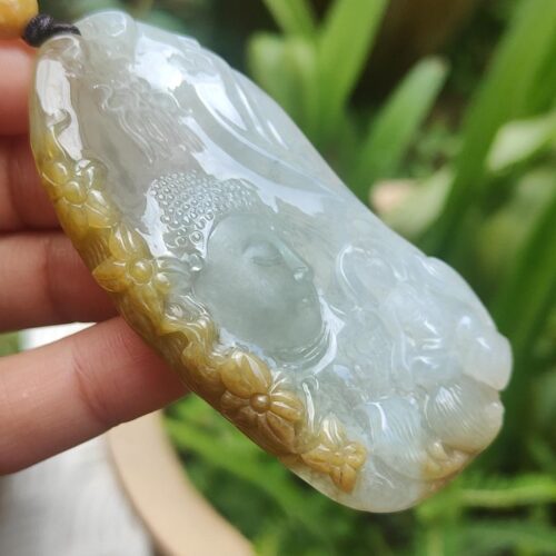 a hand holding a jade pendant