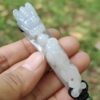 Una mano sosteniendo un colgante de jade.