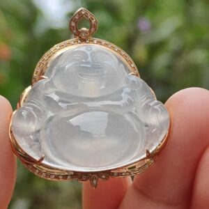 a hand holding a jade pendant