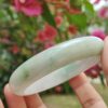 एक हाथ में कंगन पकड़े हुए