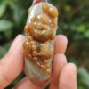 Una mano sosteniendo un colgante de jade.