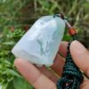 a hand holding a jade bell