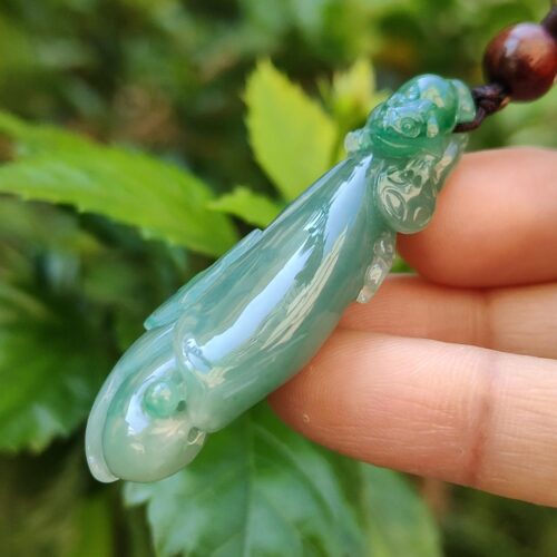 Una mano sosteniendo un colgante de jade.