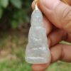 a hand holding a jade pendant