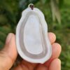 a hand holding a piece of white plastic