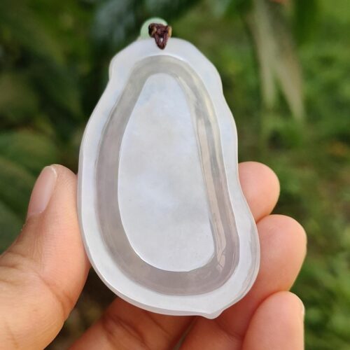 a hand holding a piece of white plastic