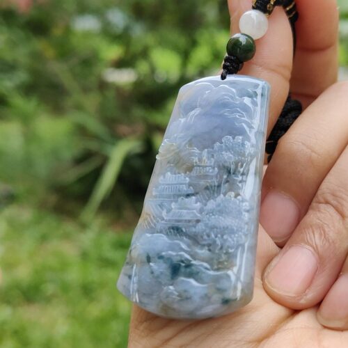 Una mano sosteniendo un colgante de jade.
