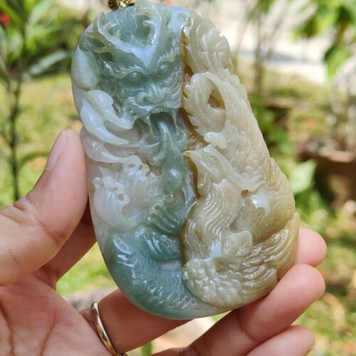 a hand holding a jade pendant