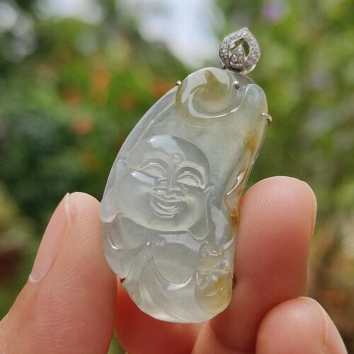 a hand holding a jade pendant