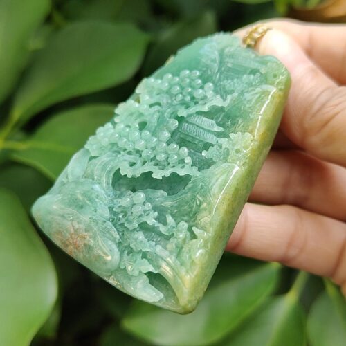 a hand holding a jade object