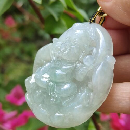 एक हाथ में जेड पेंडेंट थामे हुए