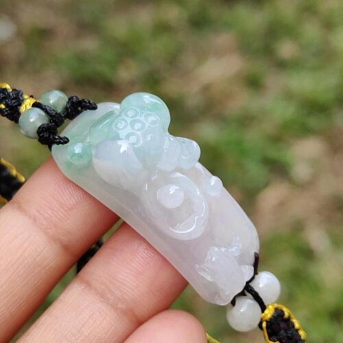 Una mano sosteniendo un colgante de jade.