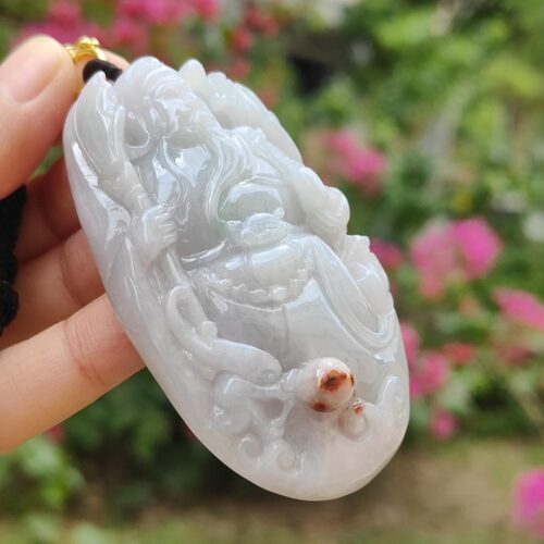 एक हाथ में जेड पेंडेंट थामे हुए