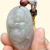 a hand holding a jade pendant