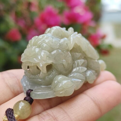 a hand holding a jade dragon