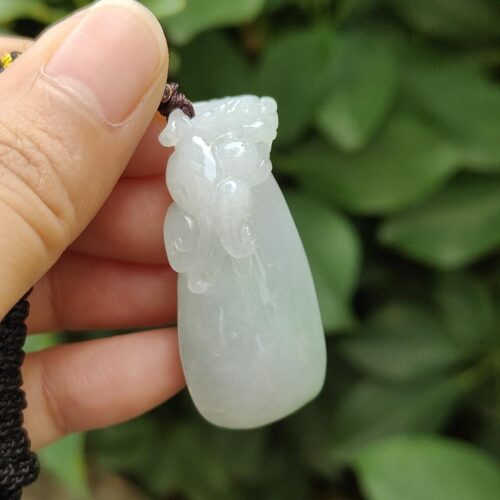 ஜேட் பதக்கத்தை வைத்திருக்கும் ஒரு கை