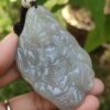 Una mano sosteniendo un colgante de jade.