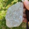Una mano sosteniendo un colgante de jade.