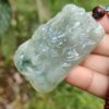 Una mano sosteniendo un colgante de jade.