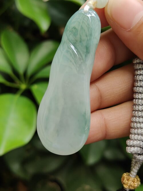 a hand holding a jade object