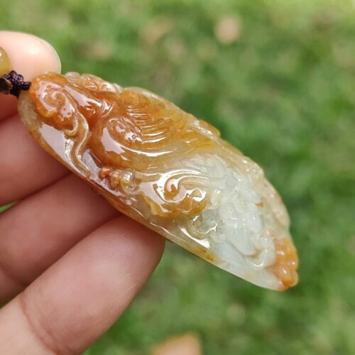 Una mano sosteniendo un colgante de jade.