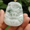 a hand holding a jade pendant
