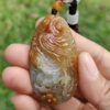 Una mano sosteniendo un colgante de piedra.