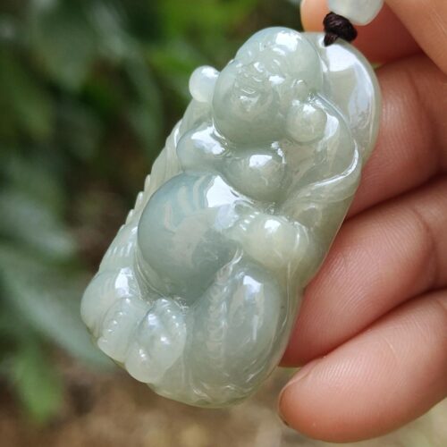 Una mano sosteniendo un colgante de jade.