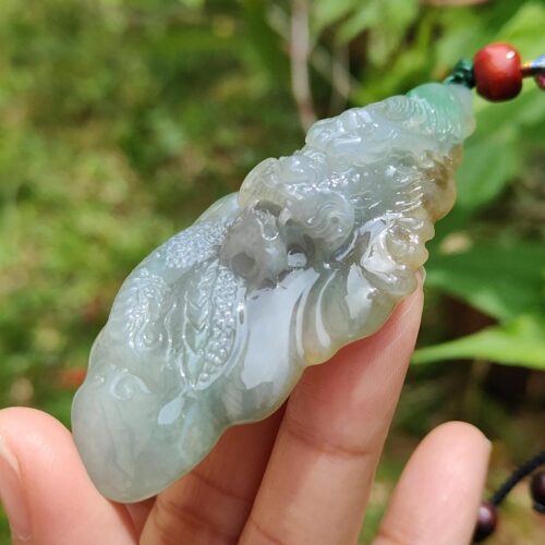 Una mano sosteniendo un colgante de jade.