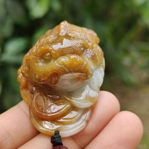 Una mano sosteniendo un colgante de jade.