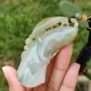 Una mano sosteniendo un colgante de jade.