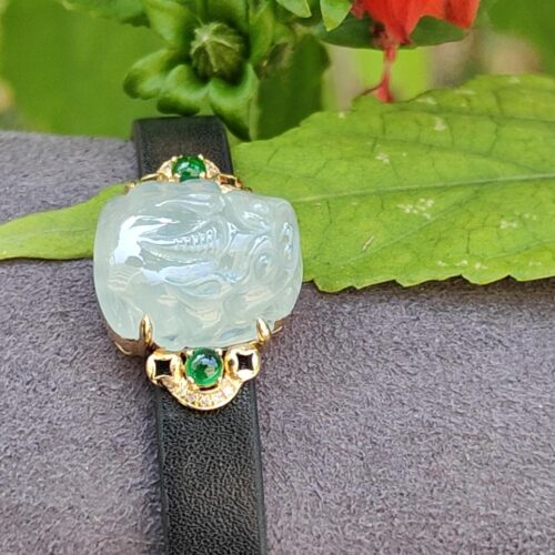 a bracelet with a stone and green gemstone on a leaf