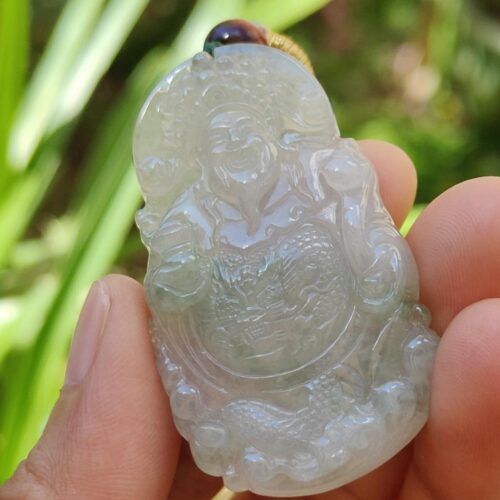 a hand holding a jade pendant