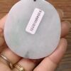 a hand holding a white stone with a white label